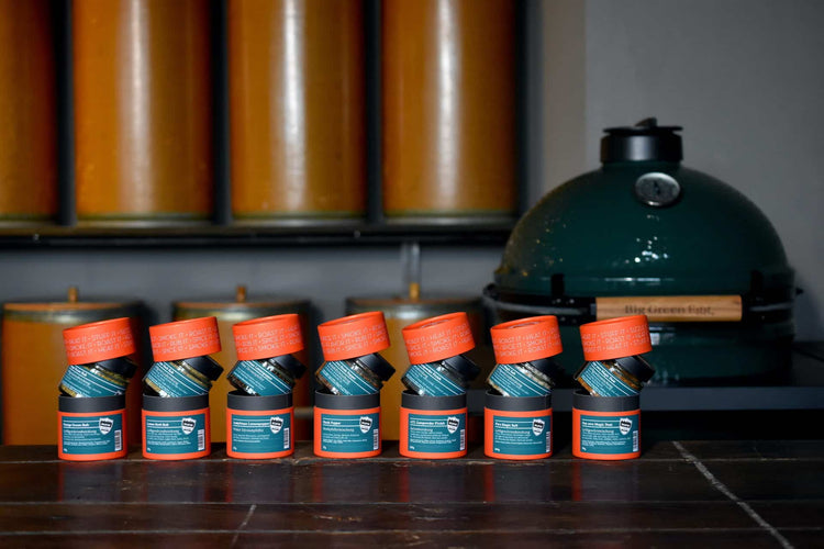 Gewürzmischungen von Big Green Egg vor Keramikgrill im Hintergrund